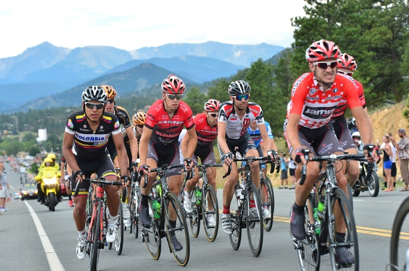 Matt Cook, right, weres the red King of the Mountains jersey as riders speed away from Estes Park on Saturday. If the stage seemed fast to roadside observers, it was: riders averaged over 27 mph over the 115-mile stage.